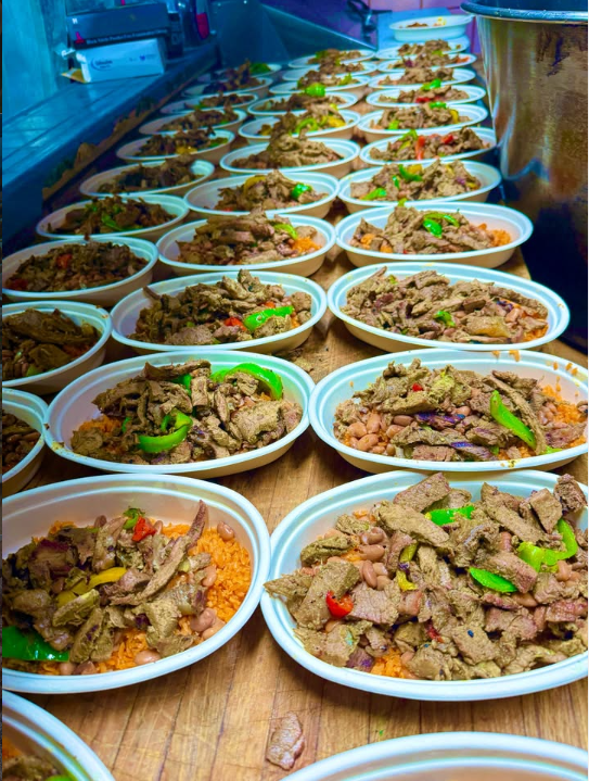 Filas de burrito bowls con carne asada, arroz, frijoles y pimientos, listos para servir
