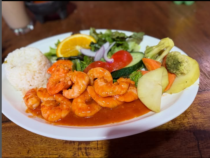 Camarones en salsa roja servidos con arroz, ensalada fresca y verduras al vapor