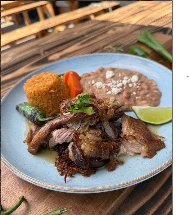 Carnitas de puerco doraditas con arroz mexicano, frijoles refritos, chile toreado y limón