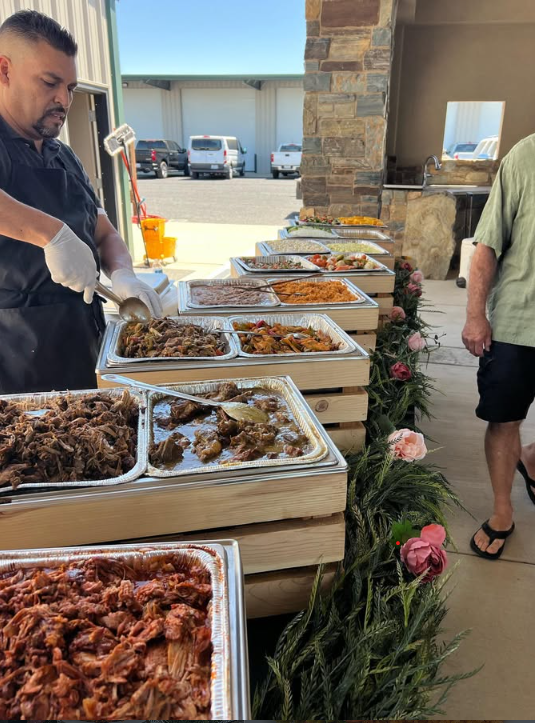 Chef de Chef Gabe sirviendo a los invitados en la línea de buffet