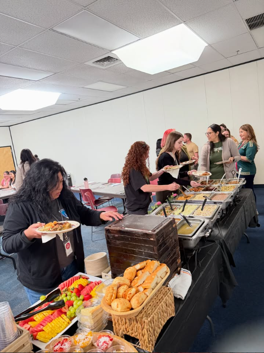 Invitados sirviéndose de la línea de buffet en un evento de empresa