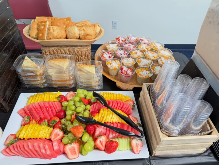 Mesa de servicio con pan, postres y charola de fruta fresca
