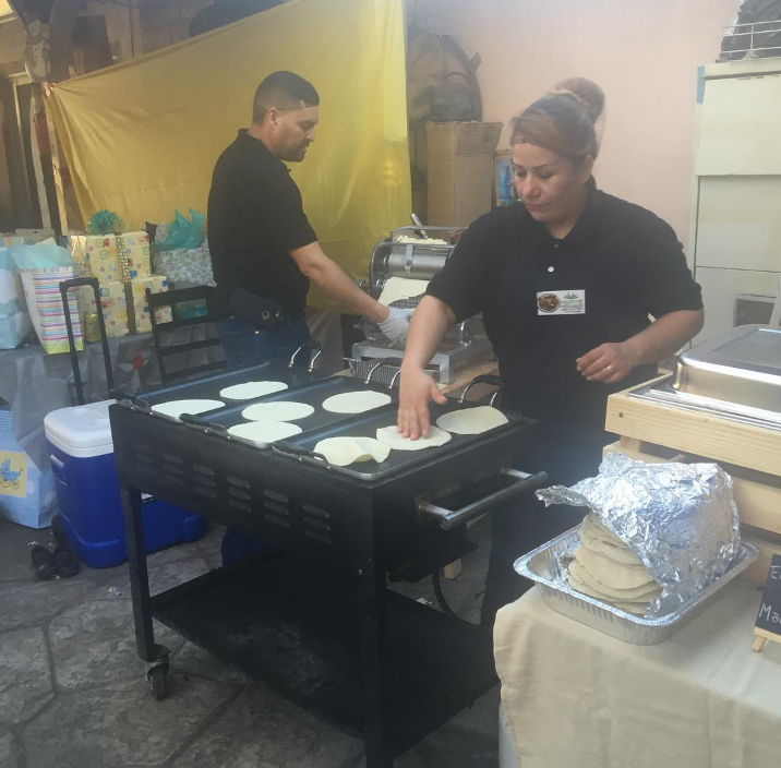 Tortillas de maíz hechas a mano cociéndose en un comal durante un evento