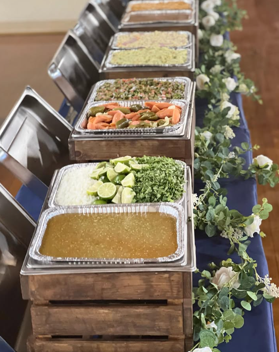 Buffet elegante con mantel azul marino y guirnalda de rosas blancas